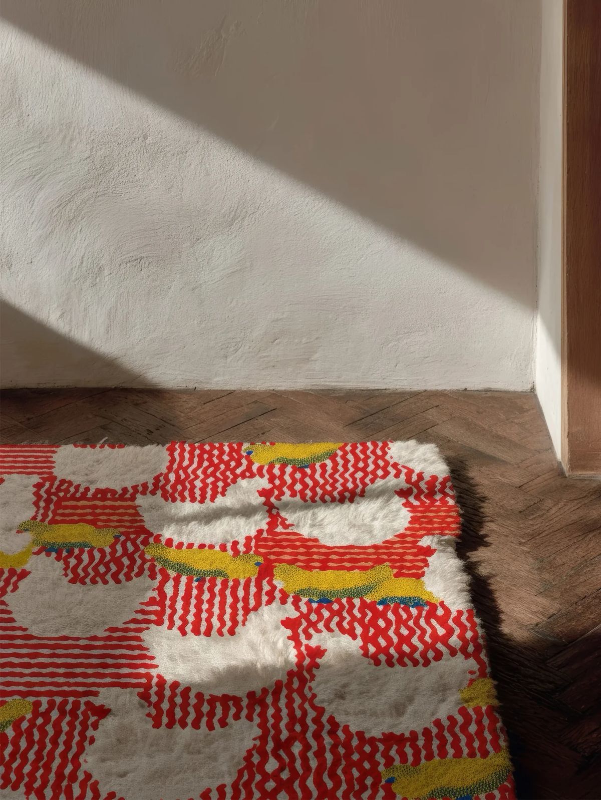 Shaggy rug with white cloud shapes, yellow accents and red zigzag stripes on a herringbone floor