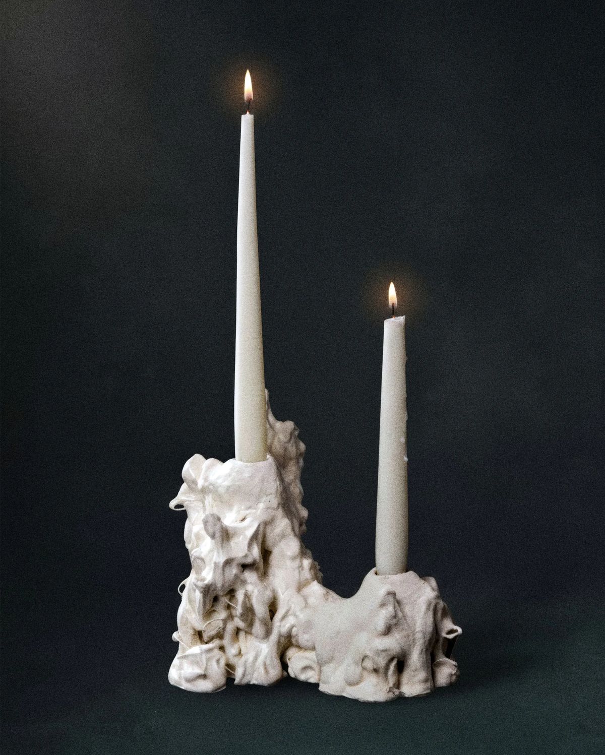 Dripping, organic white ceramic candleholder with two lit tapers of different heights