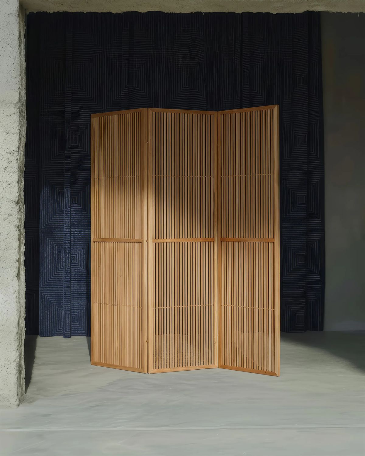 Three-panel screen of fine oak slats standing in front of a quilted navy curtain