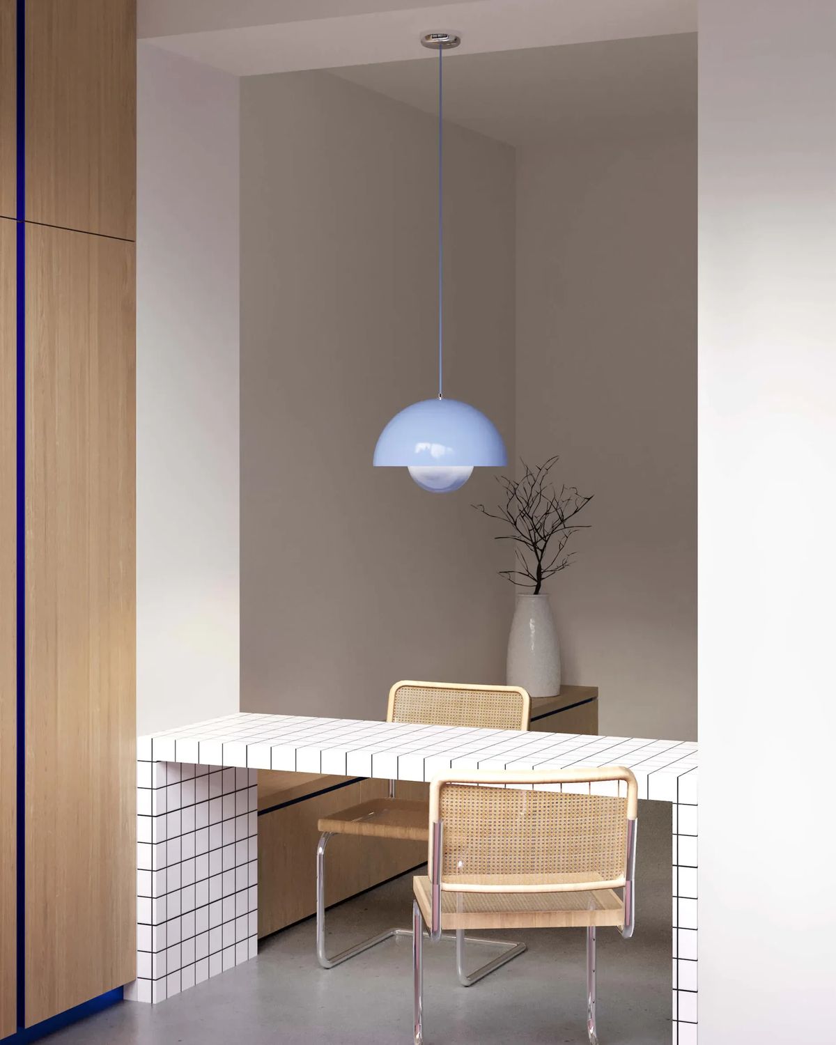 Dining nook with a white grid-tiled table, cane cantilever chairs and a pale blue dome pendant