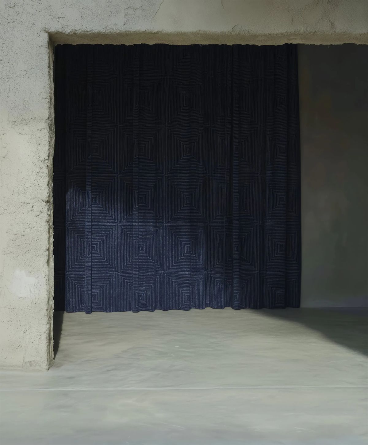 Navy curtain filling a rough plaster opening, with leaf shadows falling across the fabric